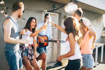 Group of happy friends having party on rooftop