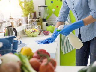Woman cleaning with a spray detergent