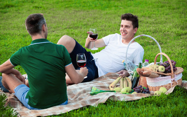 Naklejka na ściany i meble Man enjoying life on picnic outdoors with his friend