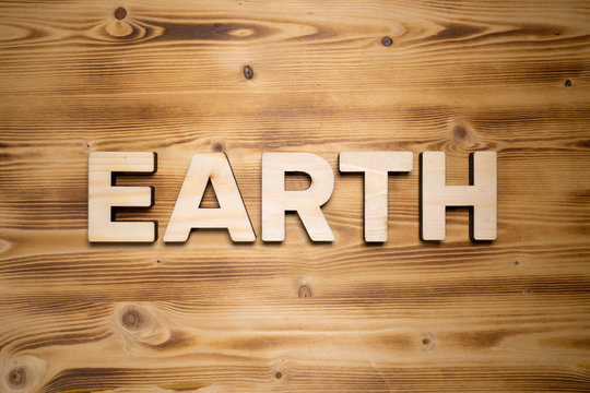 EARTH word made with building blocks on wooden board.