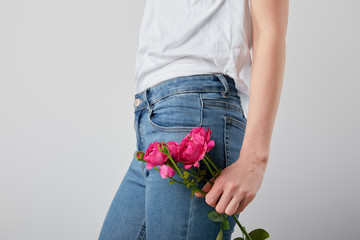 cropped view of girl holding pink roses isolated on grey