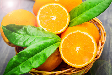 fresh oranges with leaves in wicker container