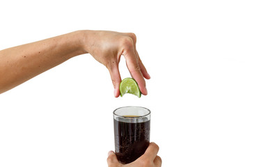 Squeezing the lime into the drink