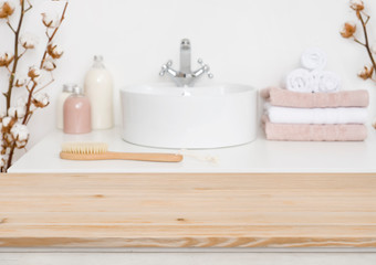Obraz na płótnie Canvas Wooden table top and blur bathroom interior on the background