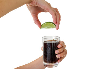 Squeezing the lime into the drink
