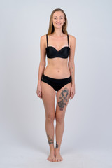 Fototapeta premium Full body shot of happy blonde woman in bikini smiling