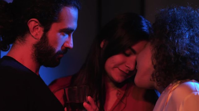 Polygamy, threesome, attraction among more people. Three people kiss and flirt 