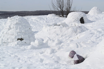 The child climbs out of the snow cave - dwelling Inuit, Igloo