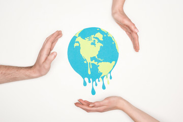 cropped view of male and female hands around paper cut melting globe on white background, global warming concept