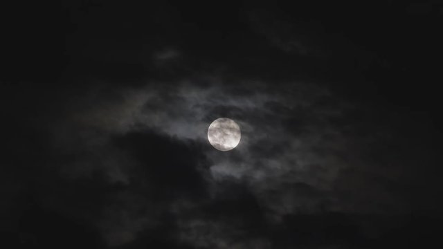 Dark black clouds covering full moon in the sky, frightful scenery