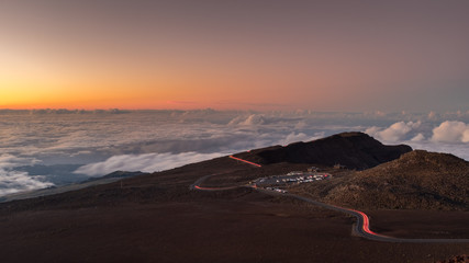 Mountain road above the clouds at sunset