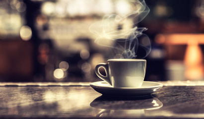 Cup of coffee on bar desk in night club