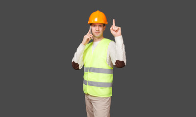 the man in a helmet speaks by phone, points a finger up