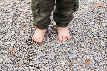 baby with bare feet on tree trunk