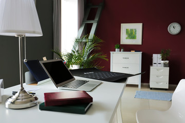 Stylish workplace with laptop in modern room