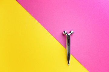 Facial massage tool on color background