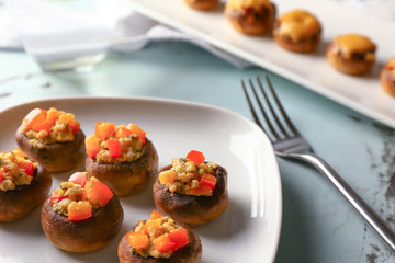 Plate with tasty stuffed mushrooms on table