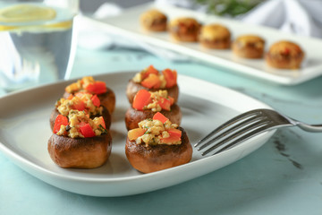Plate with tasty stuffed mushrooms on table