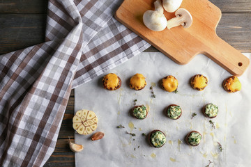 Tasty stuffed mushrooms on wooden table