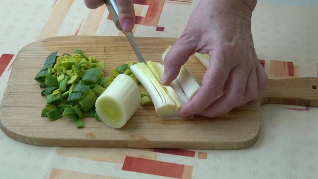 Natural fresh cutted leeks on the wooden cutting board. Closeup of sliced leek. Slices of the fresh green leek. Chopped Leek. Fresh vegetables. 