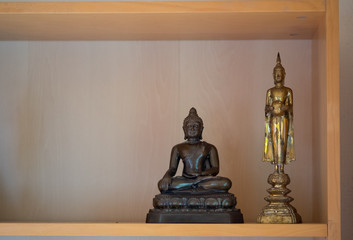 Small buddha statue on buddha shelf at Thailand home