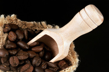 Cuillère en bois dans un sac de grains de café torréfié 