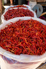 Naklejka premium Bags of bright red dried chillis for sale at an Asian food market.