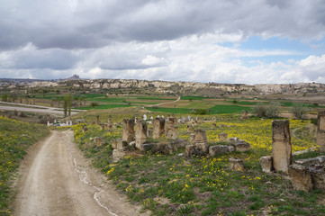 Fototapeta premium Dramatic overcast sky, panoramic view with old muslim cemetery. Spring in Cappadocia, Turkey