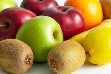 red green apples with ripe bananas and kiwi orange lemon on a white background