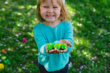 cute little girl holding easter eggs in spring