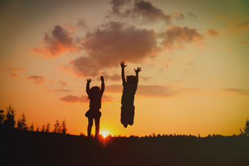 silhouette of happy boy and girl enjoy sunset nature