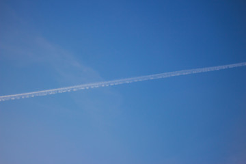 Trail after the plane in the sky.