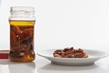 pomodori secchi sott'olio in barattolo di vetro e piatto
