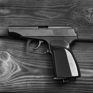 Weapon. Gun on the wooden background