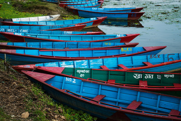 Fototapeta na wymiar Multi-colored boats on the Phewa lake in the Nepalese city of Pokhara