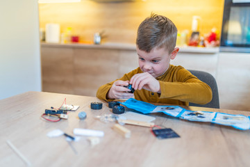 Boy Assembling Robotic Kit In the kitchen.