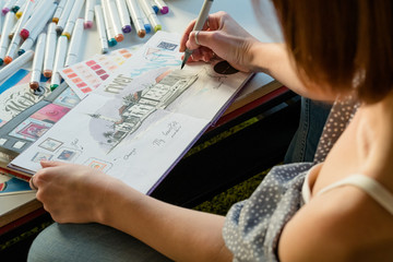 Artist sketching. Workplace inspiration. Woman painter drawing in sketchbook with palette and...
