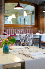 tavola apparecchiata con bicchieri e fiori