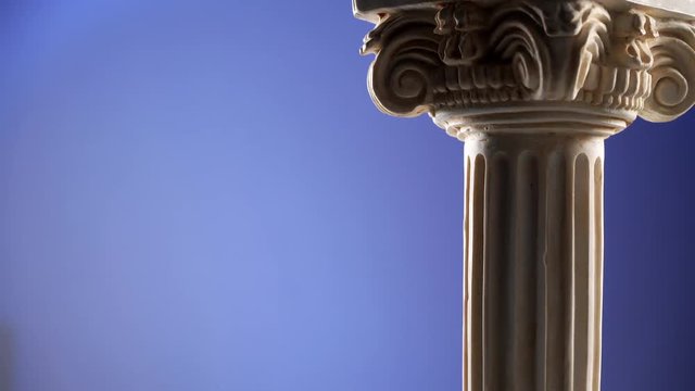 Single ancient column rotating slowly on blue background