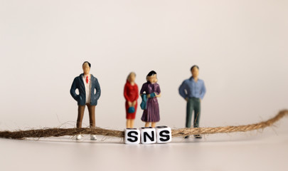 Miniature people. A SNS alphabetical cube that is connected by a string.