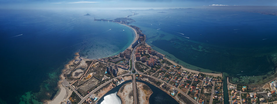 Aerial panoramic photo of buildings, villas and the beach on a natural spit of La Manga between the Mediterranean and the Mar Menor, Cartagena, Costa Blanca, Spain