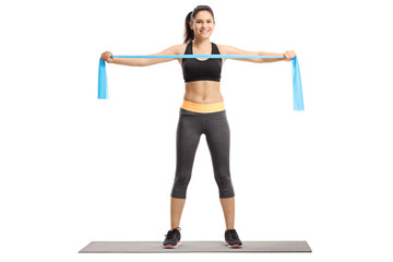 Young female exercising with an elastic rubber band