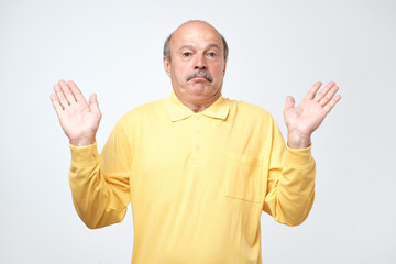 Fototapeta premium Handsome mature worker or fathert asking who cares, so what or not my problem