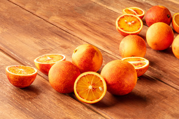 Fresh organic blood oranges on a dark rustic wooden background with a place for text