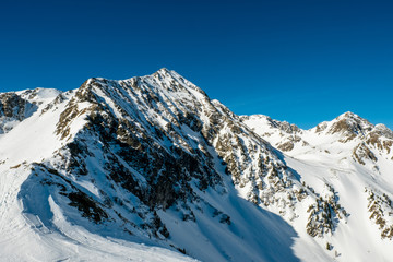 Schneebedeckter Gipfel unter blauem Himmel in den österreichischen Bergen im Winter