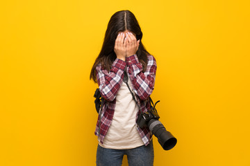Fototapeta na wymiar Photographer teenager girl over yellow wall with tired and sick expression