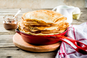 Homemade crepes with chocolate sauce, russian and ukrainian thin pancakes bliny, rustic wooden background copy space