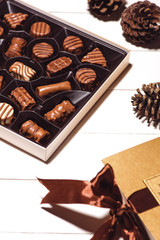 A lot of variety chocolates in box on white wooden background