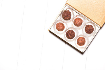 A lot of variety chocolates in box on white wooden background
