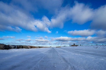 Fototapeta na wymiar Beautiful snowy road in winter under blue sky